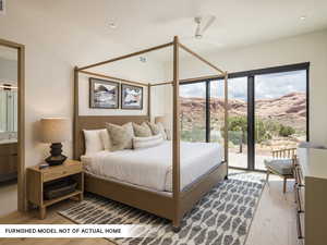 Bedroom with access to outside, wood finished floors, multiple windows, ensuite bath, and recessed lighting
