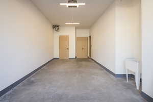 Garage featuring baseboards and a garage door opener