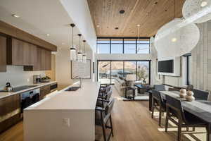 Kitchen featuring a kitchen bar, decorative light fixtures, a spacious island, appliances with stainless steel finishes, and open floor plan