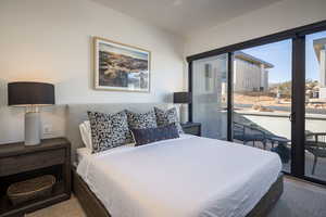 Bedroom with access to exterior and wood finished floors