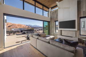 Living room featuring a high ceiling, hardwood / wood-style floors, wood ceiling, and a wall of windows