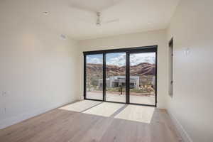 Spare room featuring ceiling fan, light wood-style flooring, baseboards, a mountain view, and recessed lighting