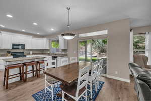 Dining room with light wood-style floors and recessed lighting
