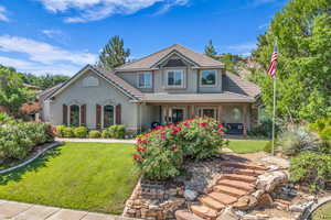 View of front of house featuring stucco siding, a tile roof, a front yard, and a porch