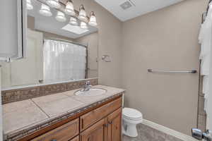 Bathroom with vanity, tile patterned floors, and curtained shower