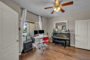 Home office with wood-type flooring and a ceiling fan