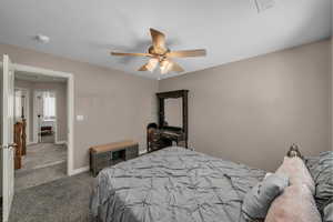 Carpeted bedroom with ceiling fan and baseboards