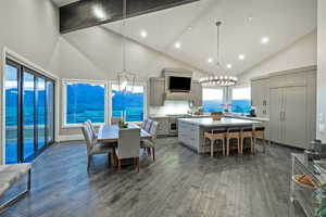 Dining space with high vaulted ceiling, a chandelier, dark wood finished floors, and recessed lighting