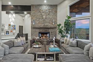 Living room with a high ceiling, a fireplace, baseboards, and a mountain view