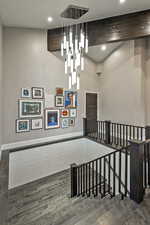 Stairway with wood finished floors, recessed lighting, a towering ceiling, and baseboards