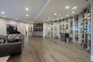 Wine room featuring bar area, recessed lighting, wood finished floors, and baseboards