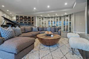 Living room with bar, recessed lighting, and baseboards