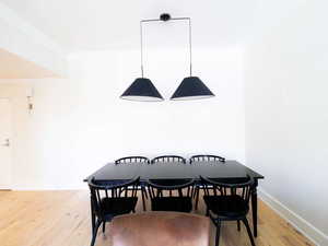 Dining room with crown molding, light wood-style floors, and baseboards