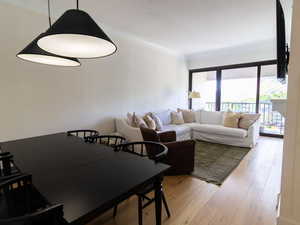 Living area with wood finished floors and ornamental molding