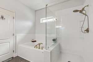 Bathroom featuring tiled shower and a bath