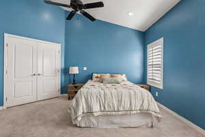 Carpeted bedroom with baseboards, high vaulted ceiling, and a ceiling fan