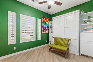 Sitting room featuring wood finished floors, a ceiling fan, and baseboards