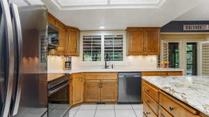 Kitchen featuring appliances with stainless steel finishes, a sink, light tile patterned floors, healthy amount of natural light, and recessed lighting