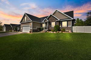 Craftsman-style house featuring stone siding, board and batten siding, an attached garage, and concrete driveway