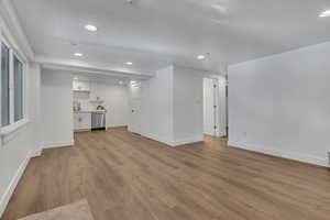 Unfurnished living room featuring recessed lighting, baseboards, and light wood finished floors