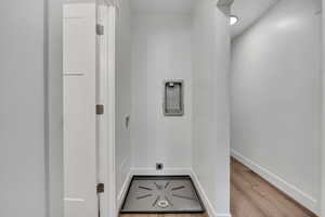 Laundry room with wood finished floors, baseboards, and hookup for an electric dryer