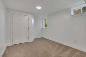 Unfurnished bedroom featuring carpet, baseboards, and a closet