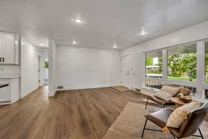 Living area featuring wood finished floors, baseboards, and recessed lighting
