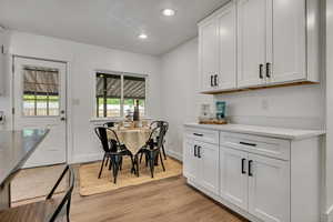 Dining room with light wood-style floors, baseboards, and recessed lighting