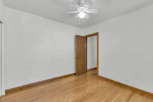 Empty room with baseboards, light wood-type flooring, and ceiling fan