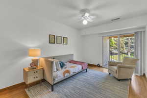Bedroom with wood finished floors, access to outside, ceiling fan, and baseboards