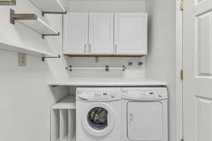 Laundry area featuring cabinet space and separate washer and dryer