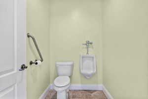 Half bathroom with toilet and urinal.