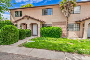 View of front of home with stucco siding and a front lawn