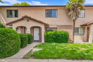 View of front of property with stucco siding and a front yard