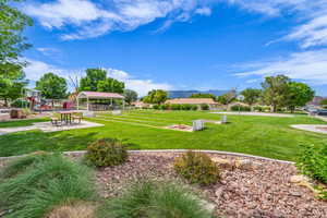 View of property's community featuring a gazebo, a lawn, and a mountain view