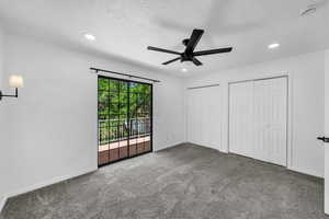 Unfurnished bedroom with access to exterior, two closets, baseboards, recessed lighting, and a textured ceiling
