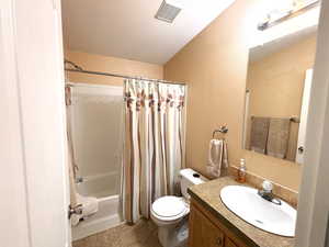 Main bathroom featuring toilet, vanity, and shower / bathtub combination with curtain