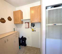 Laundry room with a heating unit, hookup for a washing machine, and baseboards