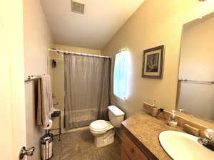 Master bathroom with vanity, vaulted ceiling, toilet, and shower / bath combination with curtain