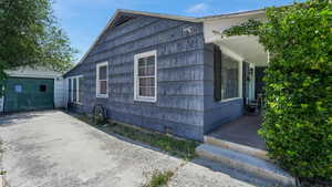 View of side of property with long driveway, porch, and a garage