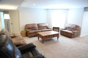 Living area with carpet, baseboards, and recessed lighting