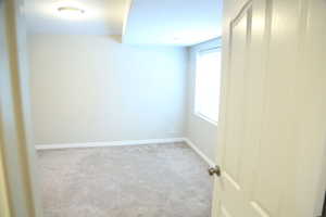 Carpeted spare room with baseboards