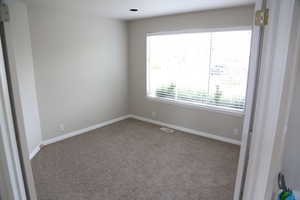 Carpeted empty room featuring baseboards