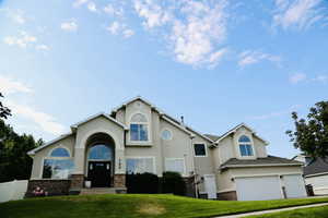 View of front of home featuring stucco siding, an attached garage, and brick siding