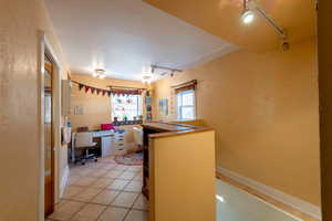 Kitchen featuring track lighting, an office area, and light tile patterned floors
