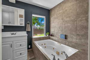 Bathroom featuring a jetted tub and vanity