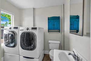 Laundry room with washer and dryer and baseboards