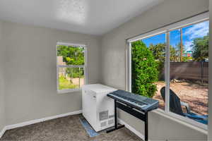 Interior space with white fridge, multiple windows, and dark colored carpet