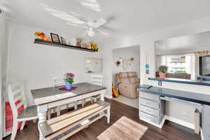Dining area with ceiling fan, dark wood-type flooring, and baseboards