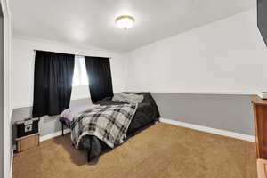 Bedroom featuring carpet, baseboards, and a textured ceiling